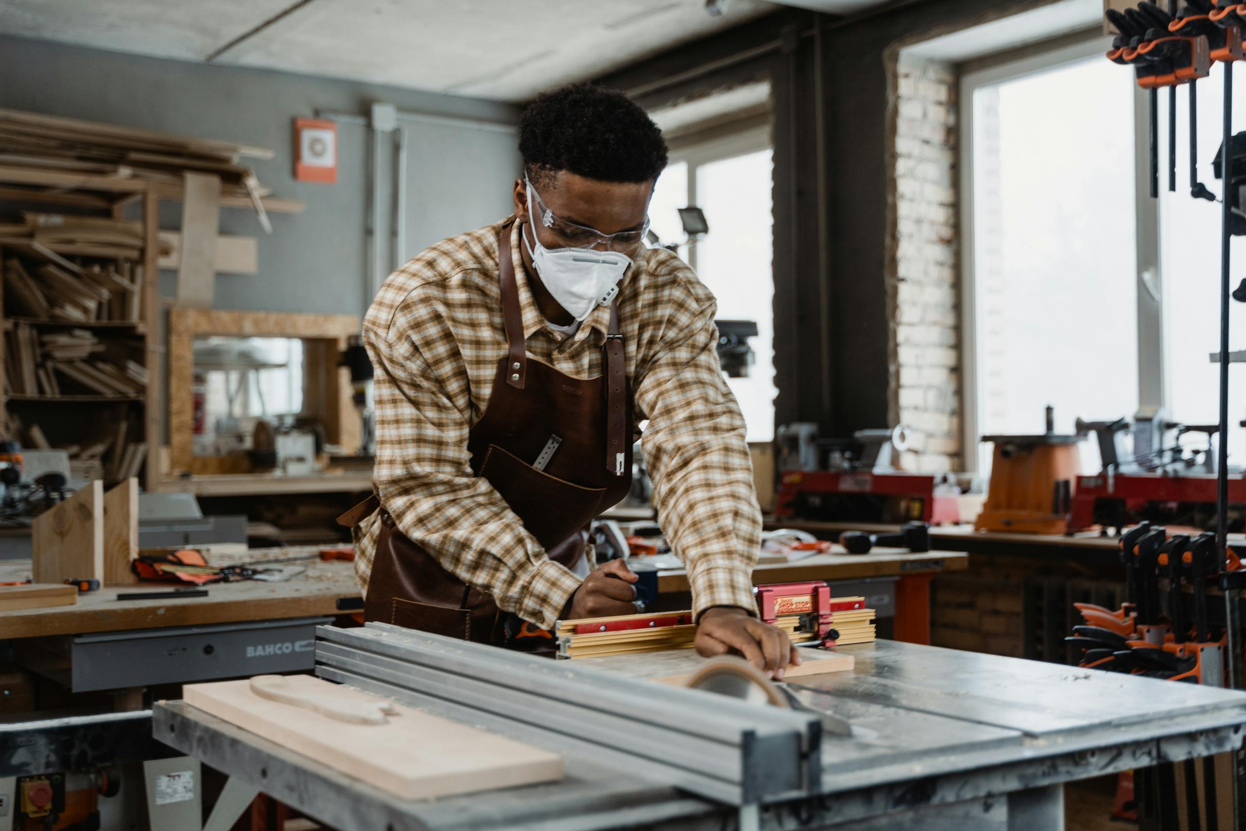 A focused craftsman demonstrating woodworking skills with tools in a workshop.