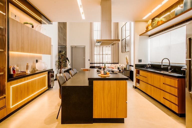 Elegant contemporary kitchen with wood cabinets, black countertops, and warm lighting for a luxurious feel.